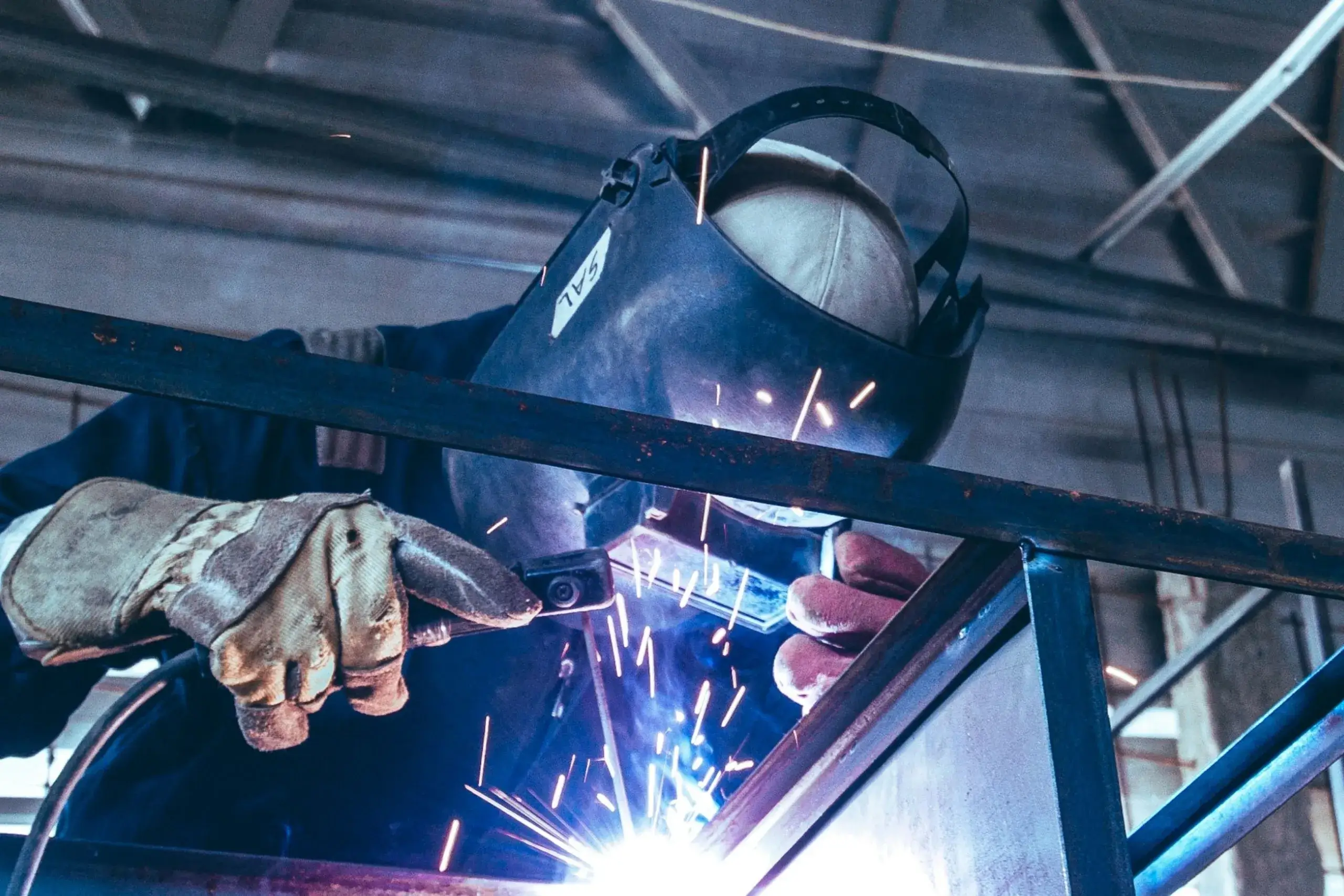 Welder in protective gear during a welding course practical at Wheelset Academy welding training centre, preparing for the welding trade test