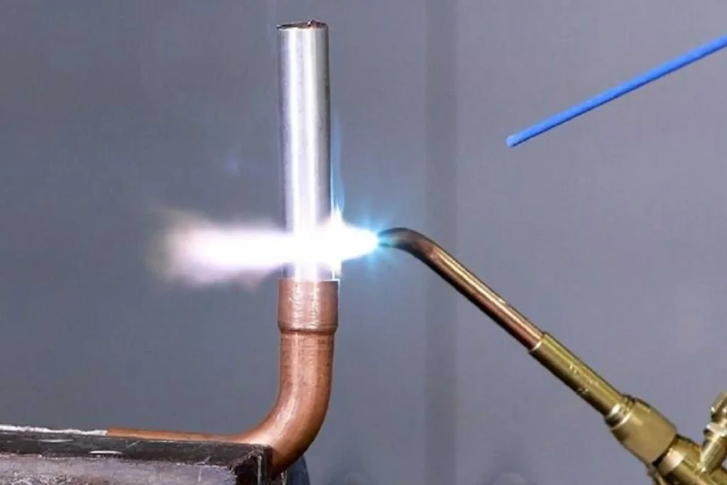 Close-up of oxy-acetylene gas welding on a metal pipe during welding short courses at Wheelset Academy.