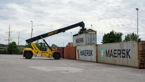 Reach Stacker C48 Operator loading and stacking shipping containers at a container terminal during practical material handling operations.