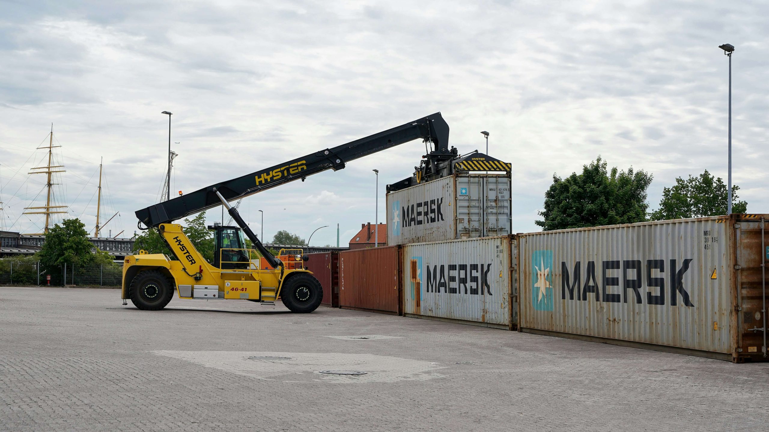 Reach Stacker C48 Operator loading and stacking shipping containers at a container terminal during practical material handling operations.