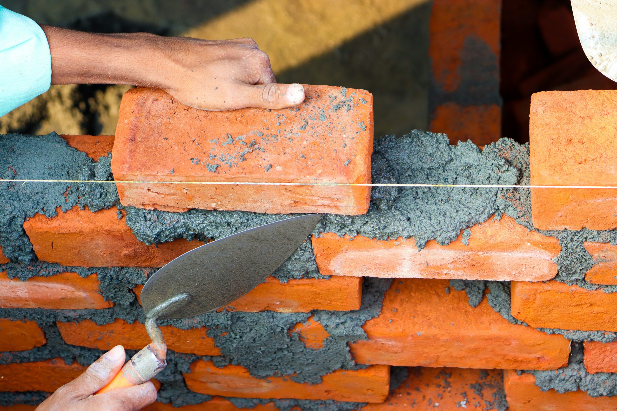 Bricklayer course learner laying face brick on a superstructure wall at Wheelset Academy