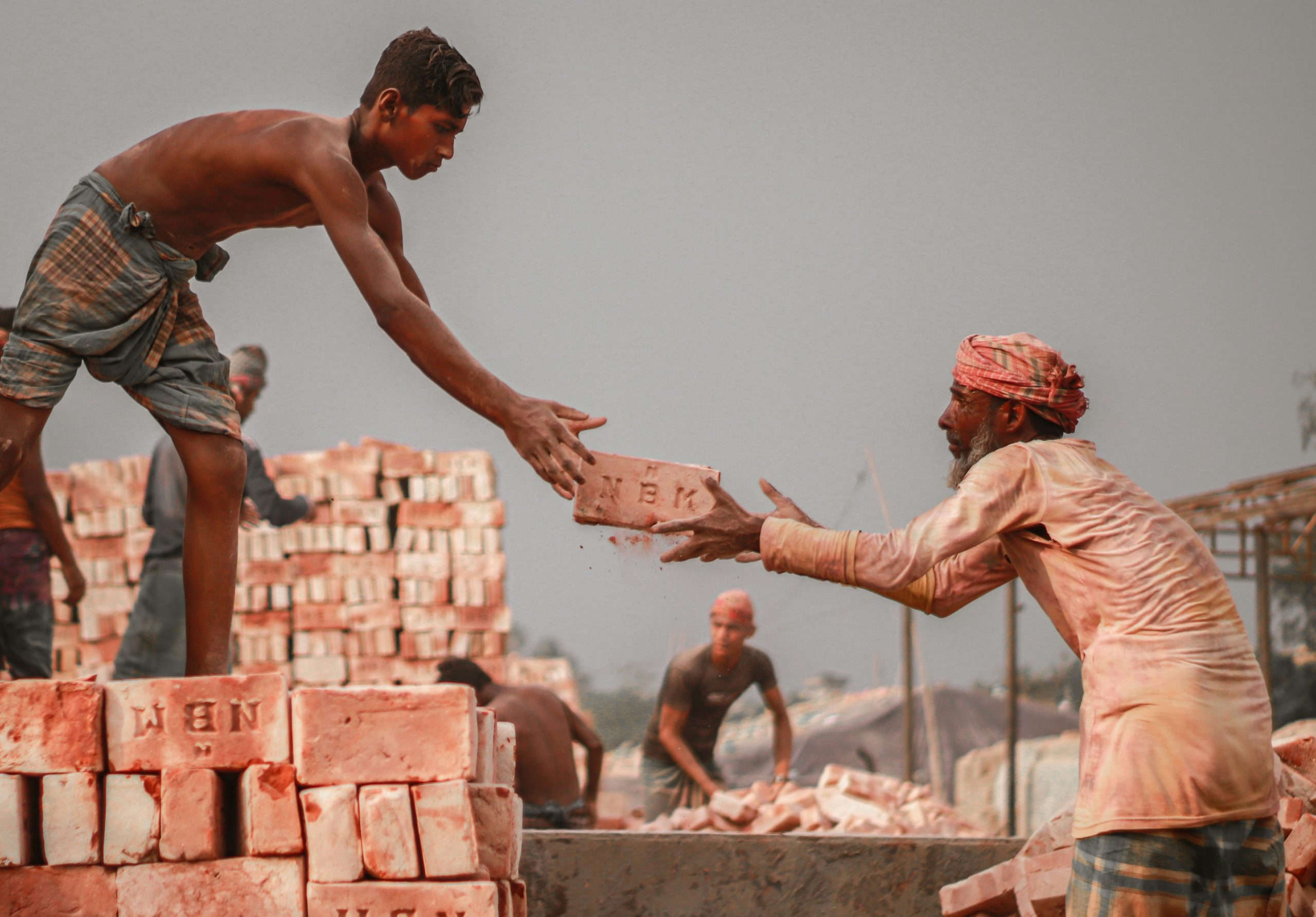 Bricklayer's Assistant learner mixing mortar and laying brick at a Wheelset Academy practical training area